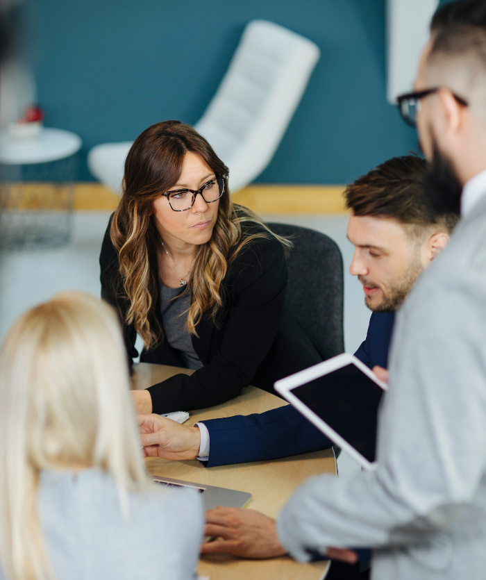 femme concentrée assise autour d'une table avec son équipe